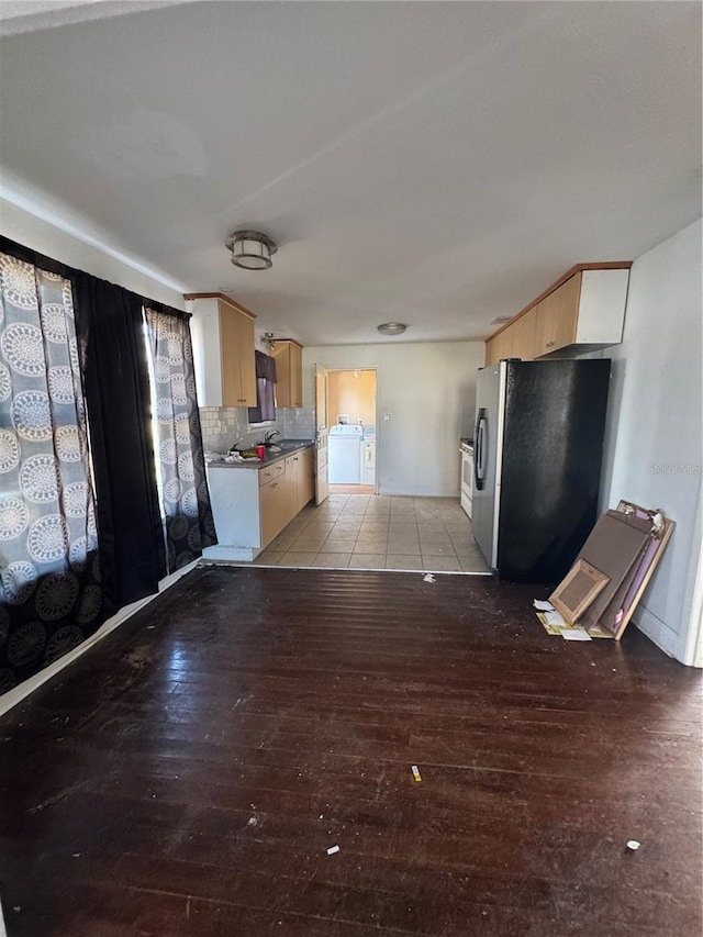 kitchen with washer / clothes dryer, light brown cabinetry, decorative backsplash, stainless steel refrigerator with ice dispenser, and light wood-type flooring