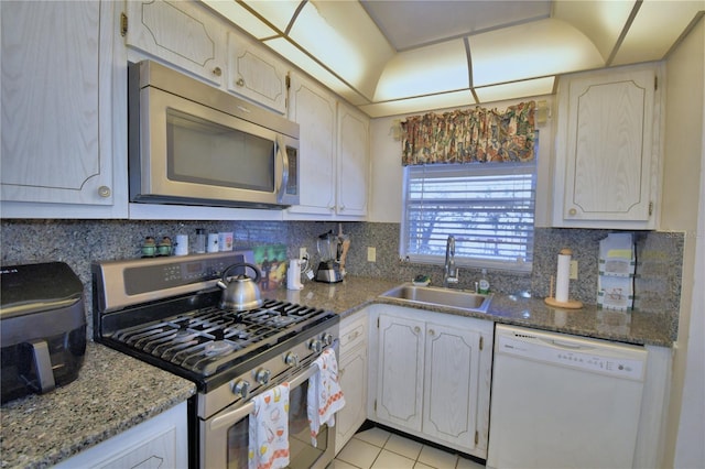 kitchen featuring a sink, stone counters, tasteful backsplash, and appliances with stainless steel finishes