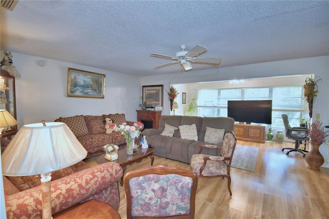 living room with plenty of natural light, a textured ceiling, and wood finished floors