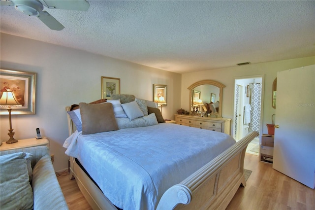 bedroom with visible vents, a textured ceiling, a ceiling fan, and light wood finished floors