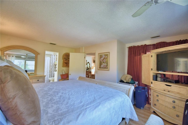 bedroom with visible vents, a textured ceiling, ceiling fan, and light wood-style flooring