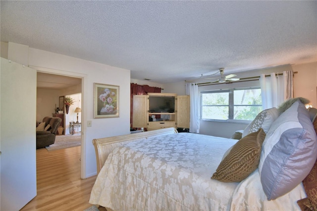 bedroom with light wood-type flooring and a textured ceiling