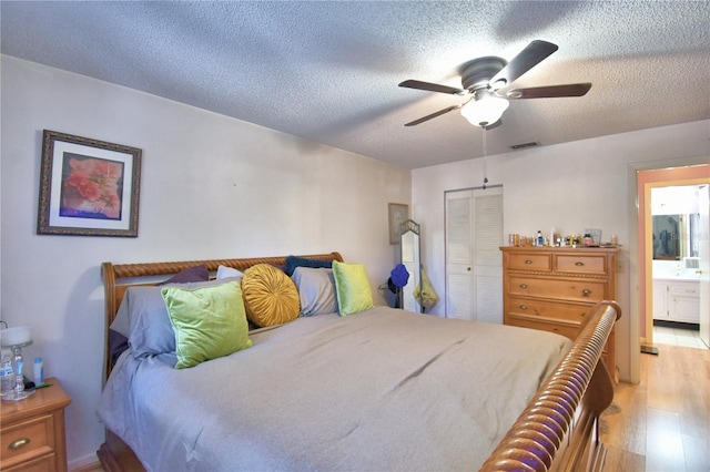 bedroom with visible vents, light wood-style flooring, a ceiling fan, a textured ceiling, and a closet