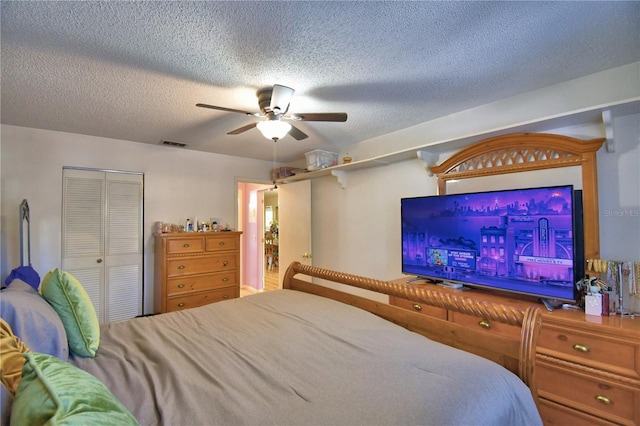 bedroom with a closet, visible vents, a textured ceiling, and a ceiling fan