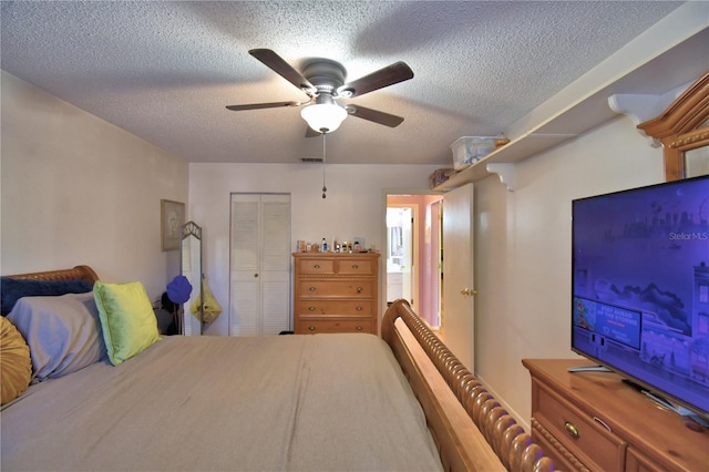 bedroom featuring a closet, a textured ceiling, visible vents, and ceiling fan