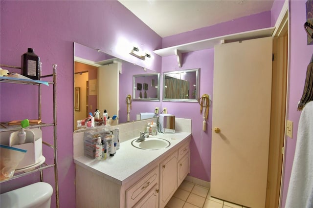 bathroom featuring tile patterned flooring, toilet, vanity, and baseboards