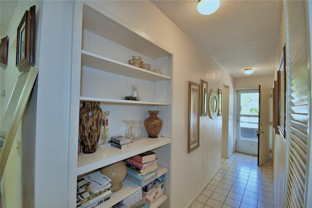 hallway featuring light tile patterned floors and a textured ceiling