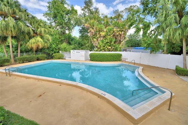 community pool featuring a patio area and a fenced backyard