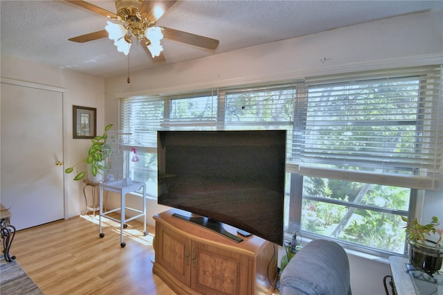 interior space with light wood finished floors, a textured ceiling, and ceiling fan