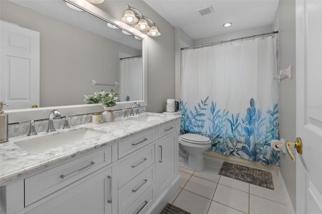 bathroom with tile patterned flooring, double vanity, toilet, and a sink