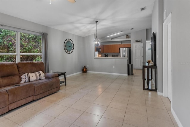 living room featuring light tile patterned floors, baseboards, visible vents, an inviting chandelier, and vaulted ceiling