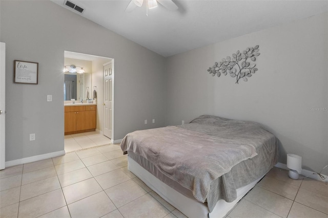 bedroom featuring visible vents, baseboards, vaulted ceiling, light tile patterned flooring, and a sink