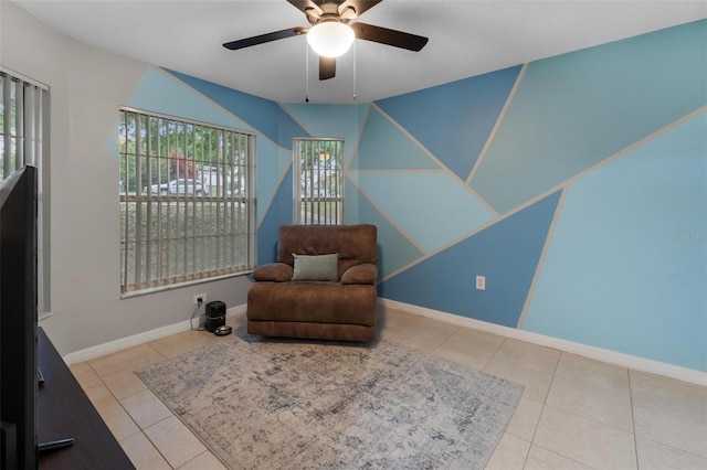 sitting room featuring tile patterned floors, a ceiling fan, and baseboards