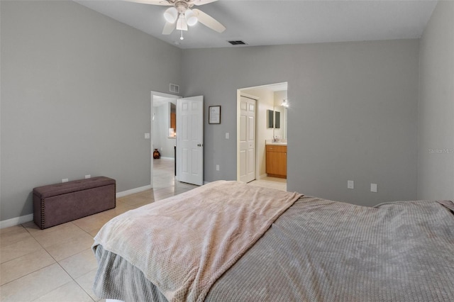 bedroom with visible vents, baseboards, vaulted ceiling, light tile patterned floors, and ensuite bath