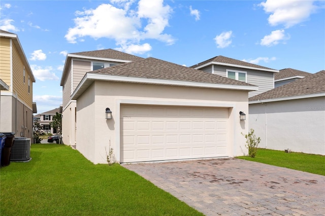 garage featuring decorative driveway and central air condition unit