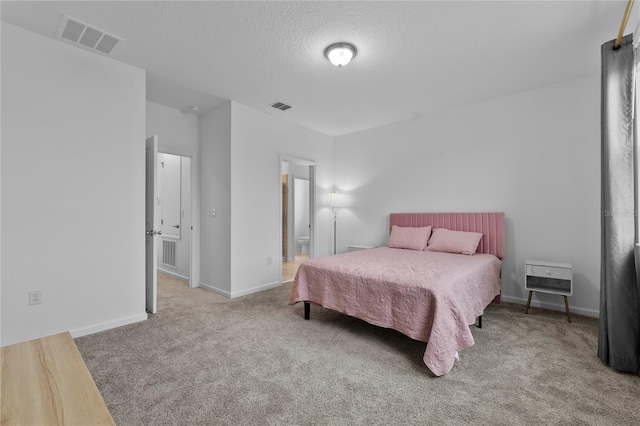 carpeted bedroom featuring visible vents, baseboards, and a textured ceiling