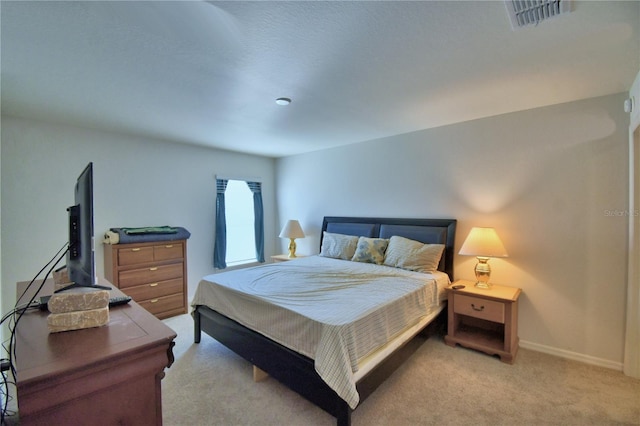 bedroom with visible vents, light carpet, and baseboards