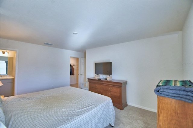 bedroom with a sink, baseboards, light carpet, and visible vents