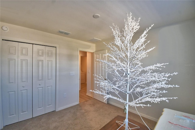 carpeted bedroom featuring visible vents, baseboards, and a closet