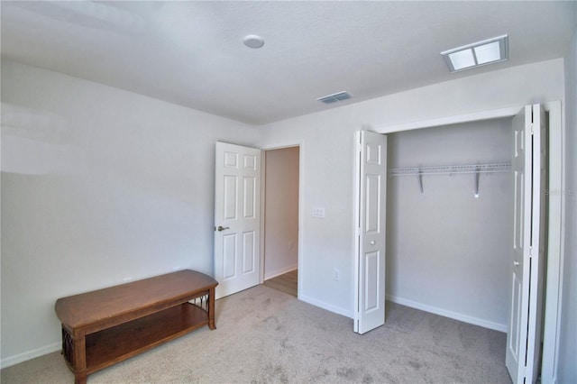 carpeted bedroom with visible vents, baseboards, and a closet