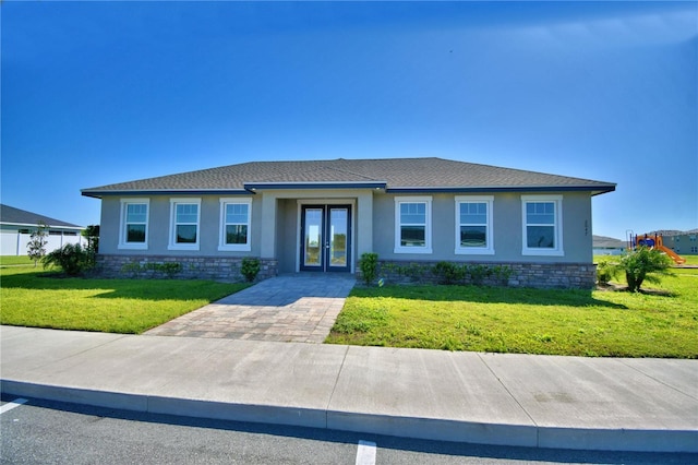 view of front of house featuring a front yard, roof with shingles, stucco siding, french doors, and stone siding