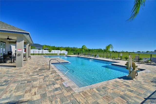 community pool with a patio and fence