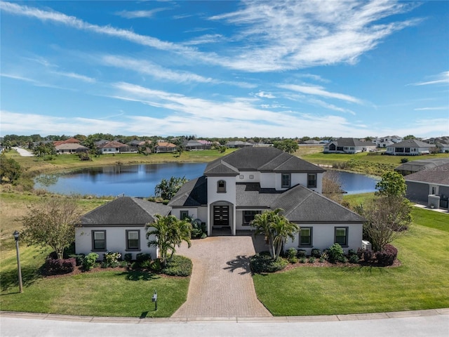 view of front of home featuring a residential view, decorative driveway, and a front lawn