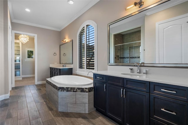 bathroom with wood finish floors, a stall shower, ornamental molding, a sink, and a bath