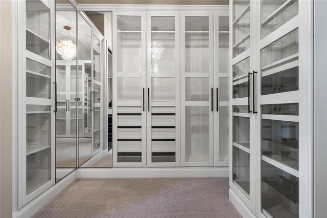 spacious closet with carpet floors and a chandelier