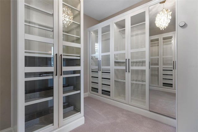 walk in closet featuring a notable chandelier and carpet