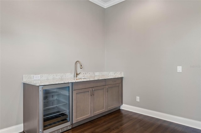 bar with wet bar, dark wood-style floors, beverage cooler, and baseboards