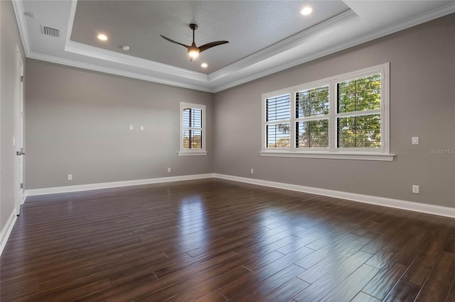 unfurnished room featuring visible vents, crown molding, a raised ceiling, and dark wood-type flooring