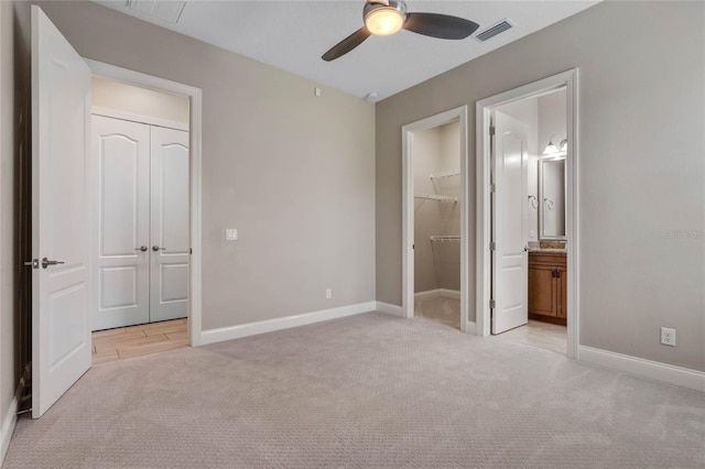 unfurnished bedroom with visible vents, light colored carpet, and baseboards