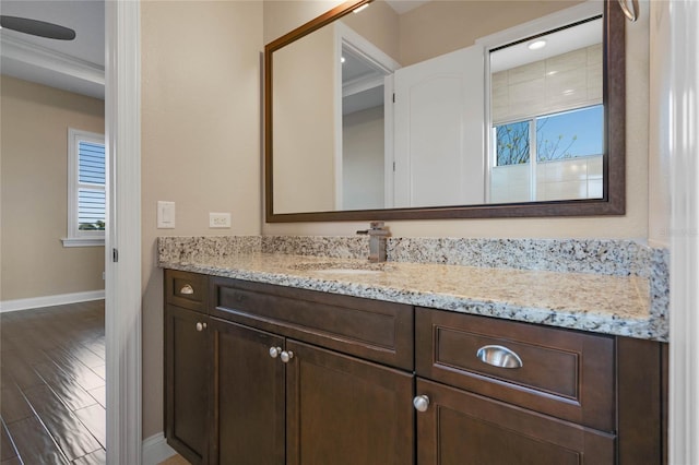 bathroom featuring vanity, wood finished floors, and baseboards