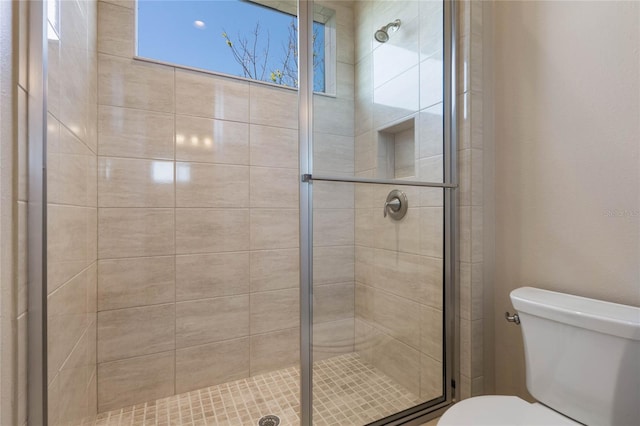 bathroom featuring toilet and a stall shower