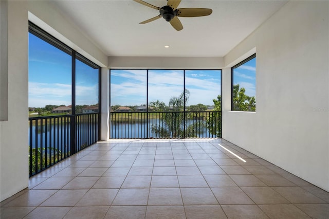 unfurnished sunroom with a water view and ceiling fan