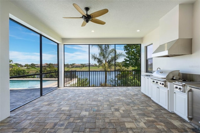 unfurnished sunroom with a water view and a ceiling fan