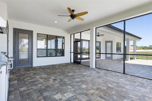 unfurnished sunroom with a ceiling fan