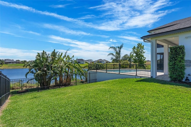 view of yard featuring a fenced in pool, a water view, and fence