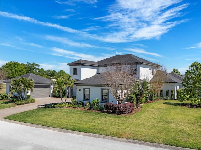 view of front facade featuring stucco siding, driveway, an attached garage, and a front yard