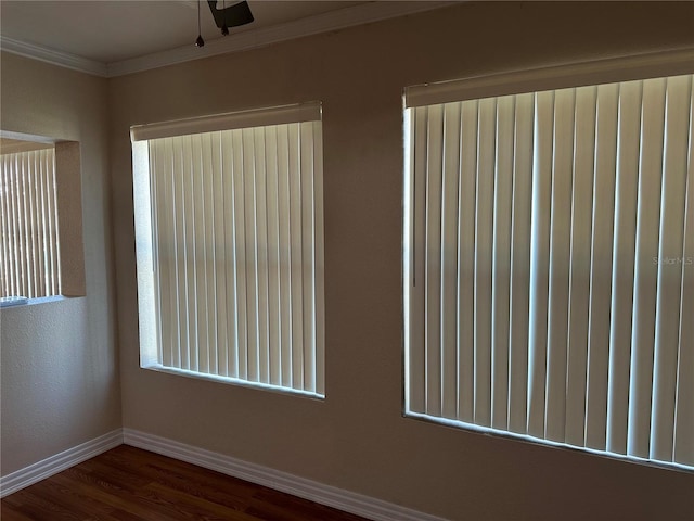 unfurnished room featuring a ceiling fan, crown molding, baseboards, and wood finished floors