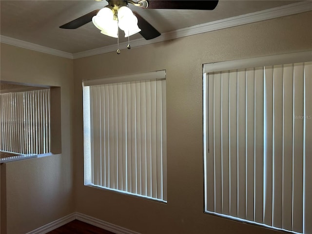 spare room with crown molding and baseboards