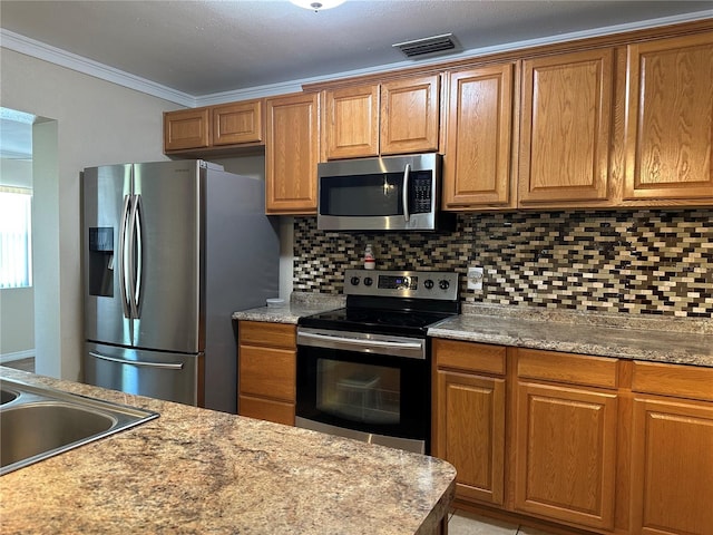 kitchen featuring brown cabinetry, visible vents, ornamental molding, appliances with stainless steel finishes, and backsplash