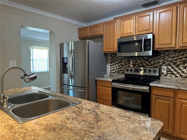 kitchen featuring visible vents, crown molding, decorative backsplash, stainless steel appliances, and a sink