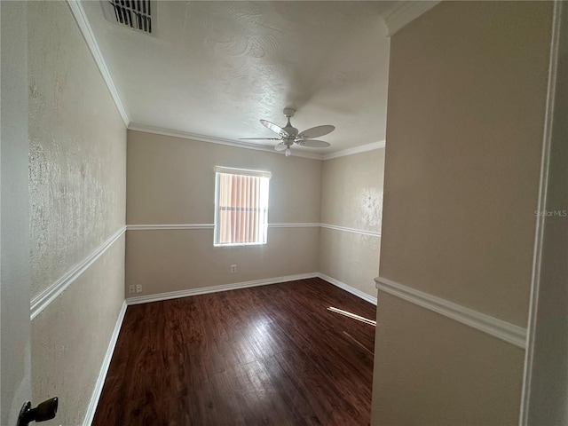 spare room featuring visible vents, wood finished floors, crown molding, baseboards, and ceiling fan