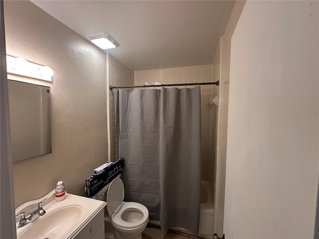 bathroom featuring a shower with shower curtain, toilet, vanity, and a textured wall