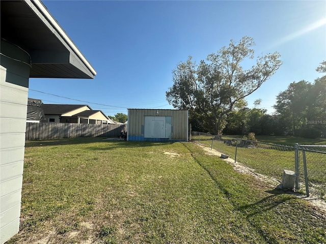 view of yard with an outbuilding, a fenced backyard, and a shed