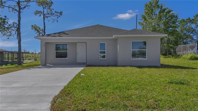 view of front of home featuring stucco siding, a front yard, and roof with shingles