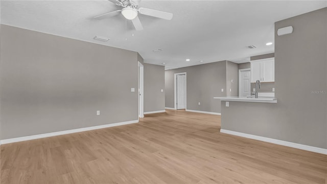 unfurnished living room featuring light wood-type flooring, visible vents, a ceiling fan, recessed lighting, and baseboards