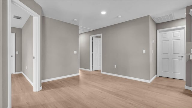 empty room featuring visible vents, baseboards, and light wood-style flooring